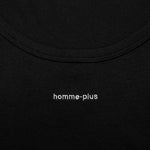 Close-up of a black garment with 'homme-plus' branding.