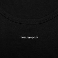Close-up of a black garment with 'homme-plus' branding.