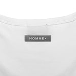 Close-up of a white shirt with a 'HOMME+' label on a white background