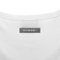 Close-up of a white shirt with a 'HOMME+' label on a white background